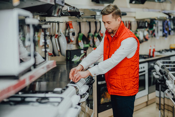 An employee of a home appliance store in the kitchen goods department