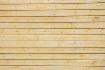 Obraz premium The polished wooden boards are tightly knocked together, covered with a transparent varnish. Wood texture, wooden wall made of boards.