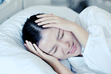 Obraz na płótnie Canvas Asian insomnia and headache in bed