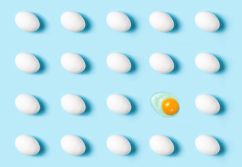 Poultry products. Pattern of white chicken eggs on a blue background. One egg is broken.