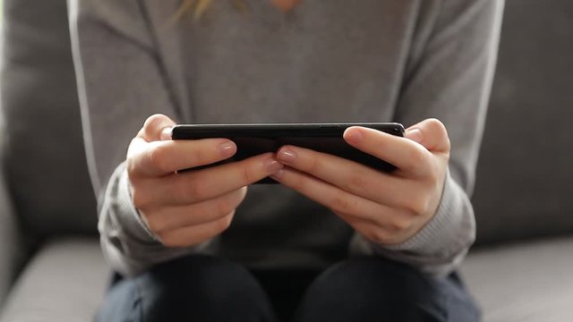 Close up 4k video of a young woman using a smartphone at home.