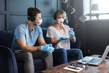 Radio hosts disinfecting hands before going live