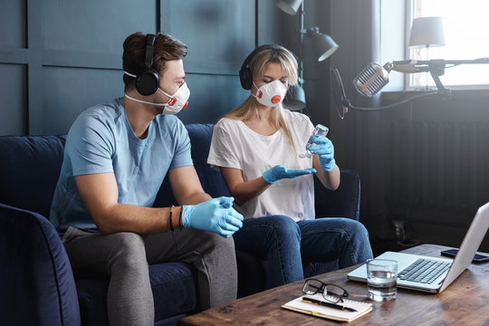 Radio hosts disinfecting hands before going live