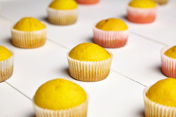 Cupcakes on white background. Muffins on wooden table, closeup. Homemade bakery