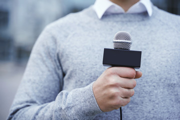 Male hand with a reporter microphone