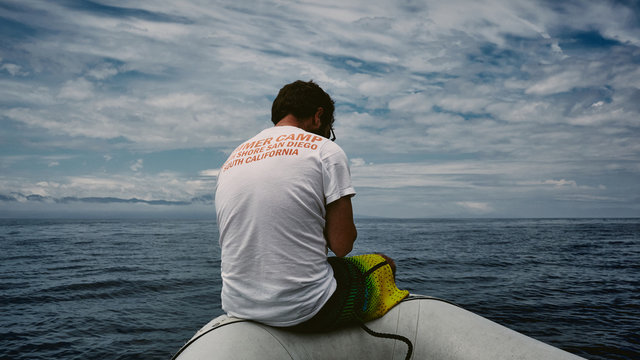 young man looking out to sea from boat