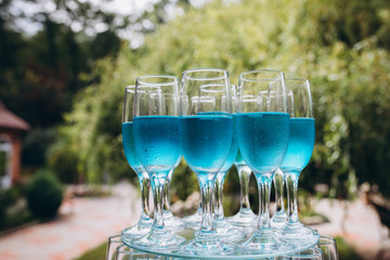 Champagne glasses. Wedding slide champagne for bride and groom. Colorful wedding glasses with champagne. Catering service. Catering bar for celebration. Beauty of bridal interior for wedding