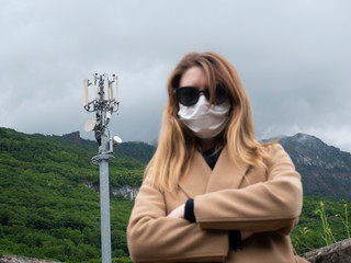 Young woman with protective mask angry with telecommunications antenna