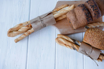 Grissini sticks with homemade bread on a light wooden background with place for copy space. Bread sticks on a light background