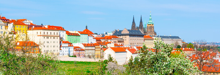 Spring in Prague. Blooming trees and lush greenery in Strahov Gardens with Prague Castle on background. Prague, Czech Republic