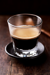 Coffee in glass cup on rustic wooden background. Close up.	