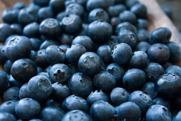Closeup of blueberry fruit on a wooden tray