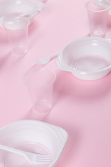Plastic utensils on a pink background. Not environmental, pollution.