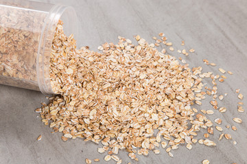A jar of oatmeal is scattered on the table, the best food for breakfast, healthy food.