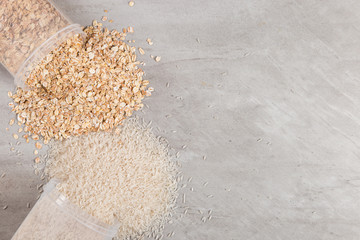 Cans of rice and oatmeal are scattered on the table. Useful complex carbohydrates, proper nutrition.