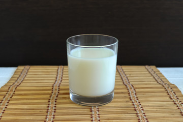 A glass of natural milk. Milk in a glass on a wooden background
