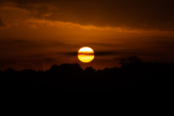nascer do sol com silhueta de árvores e montanhas