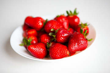 Close up. Fresh ripe delicious strawberries in a white bowl isolated on white background. Beautiful Italian red strawberry. European eco food without pesticides and additives in Milan, Lombardy, Italy