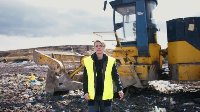 Woman worker on landfill, waste management and environmental concept.