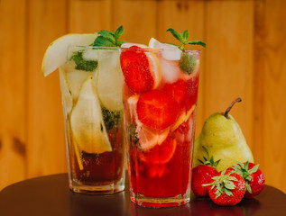 Fresh cold lemonade with strawberries and lemon on wooden background. Citric, healthy. Copy space