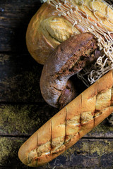 Delicious textured black bread, white loaf, baguette. Against the background of a rustic in the 1990s grid.