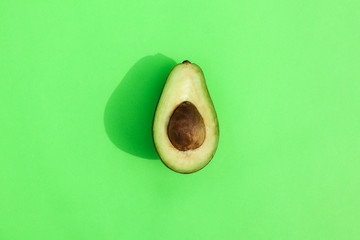 avocado cut on a colored background top view with a hard shadow