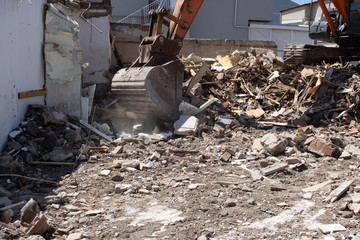 Fototapeta na wymiar excavator loading debris of a destroyed building