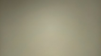 Beige background with lighting in the middle of the sheet. Paper or cardboard