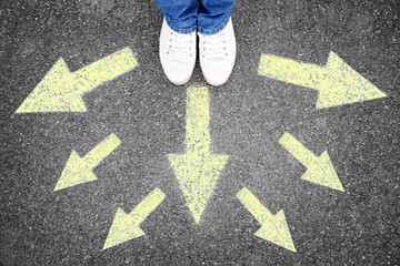 Woman standing on road near arrows, top view