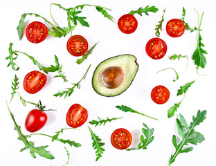 Halved avocado and tomatoes with rucola leaves  isolated on a white background. Top view.