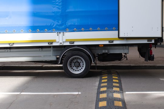 truck rear wheels and speed bump on the road