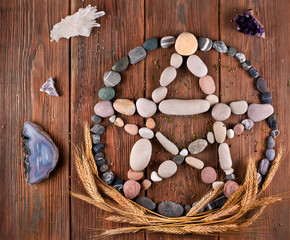 Fototapeta na wymiar Pentagram made of stones with wheat ears and crystals on a wooden background. Top view.