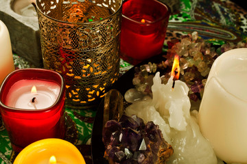 Burning candles with amethyst and quartz crystals and agate stone.