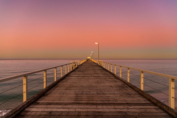 pier at sunset over beach
