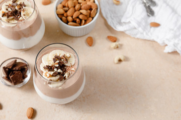 Chia seeds pudding with chocolate and banana smoothie in a glass on beige background. Healthy vegan breakfast with alternative milk and superfoods. Top view.