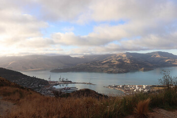Christchurch landscape with blue water and mountains in the background. Surrounded by clouds