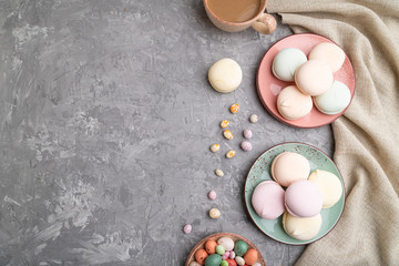Colored zephyr or marshmallow with cup of coffee and dragees on a gray concrete background. top view, copy space.