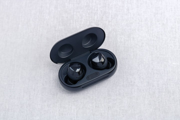 Obraz na płótnie Canvas An opened black wireless earbud charging case - Front downward side angle view.
