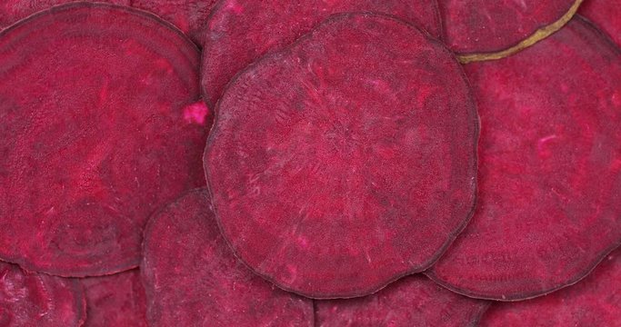 Sliced ​​red beets rotate in the frame, the frame is parallel to the beets. The texture of beets, organic, natural, dietary, fresh, preservative-free, juicy, vegetarian vitamin, nutrition, red. Three 