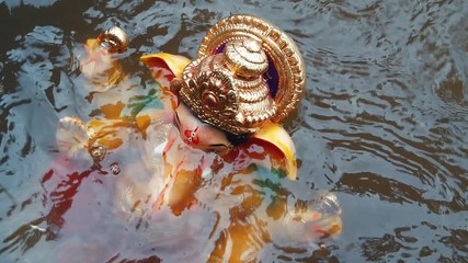 An Indian god Ganesha half immersed in water during Ganesha Chaurthi Festival