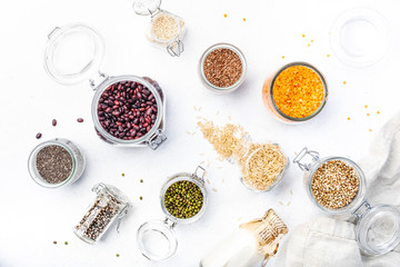 Zero waste and  lifestyle. Plastic free storage and cooking concept. Various organic superfoods, beans, grains, cereals, legumes, seeds in reusable cans and jars. Copy space top view. White background