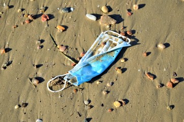 disposable face mask on the beach
