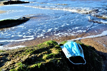 disposable face mask on the beach
