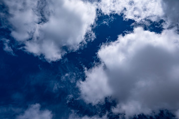 Deep blue sky being covered by clouds coming from two directions