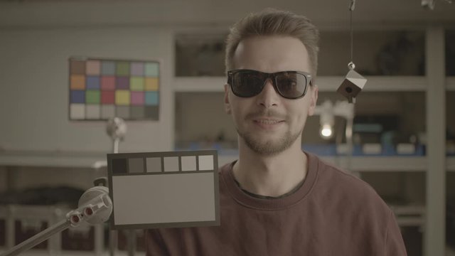 RAW video, ungraded. Man testing professional film camera. ColorChecker Gray Scale, Classic Card and spidercube. It helps to ensure eccurate color balance. RED MONSTRO, Lens 32 mm