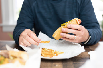 Closeup of a man eating a hotdog and fries