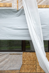 Plywood wall covered in  sheeting, in a construction background