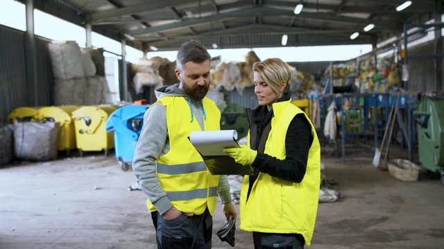 Man and woman workers on landfill, waste management and environmental concept.