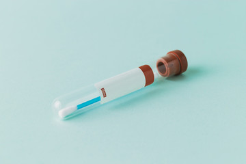 One single glass test tube with a blue cotton test swab inside