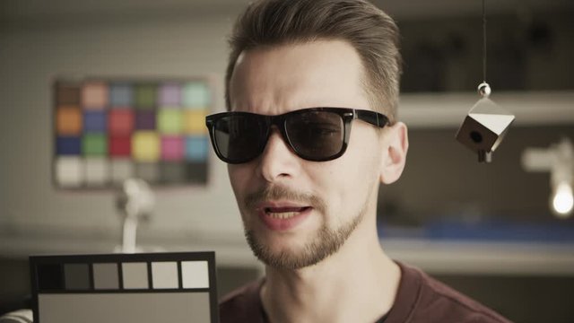 RAW video, ungraded. Man testing professional film camera. ColorChecker Gray Scale, Classic Card and spidercube. It helps to ensure eccurate color balance. RED MONSTRO, Lens 50 mm